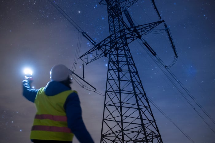 Person working on electrical pylons at night.