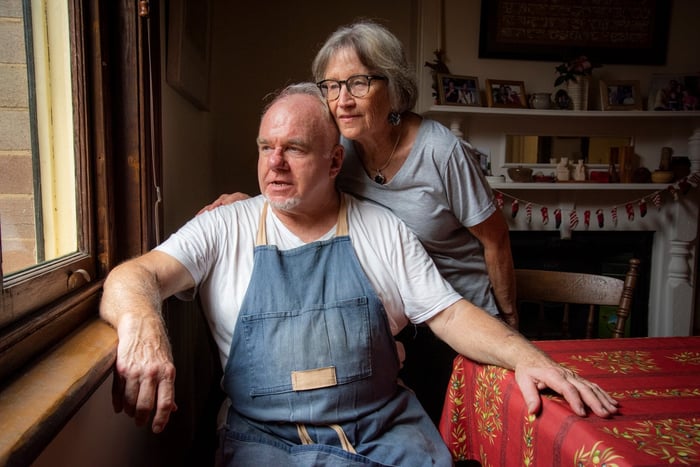Two people looking out a dining room window. 
