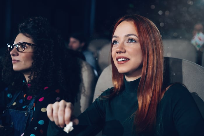 A person watching a movie while eating popcorn.