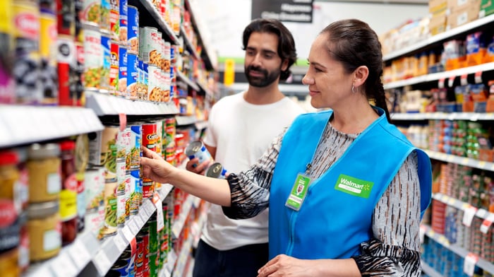 Walmart associate with a customer in a store.