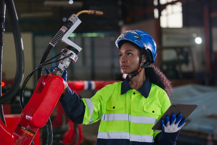 A technician examines a robotic arm.