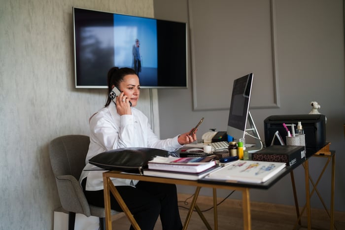 Businessperson talking on a smartphone while sitting in an office.