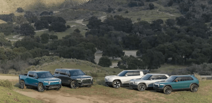 All Rivian electric truck and SUV models parked on a hill.