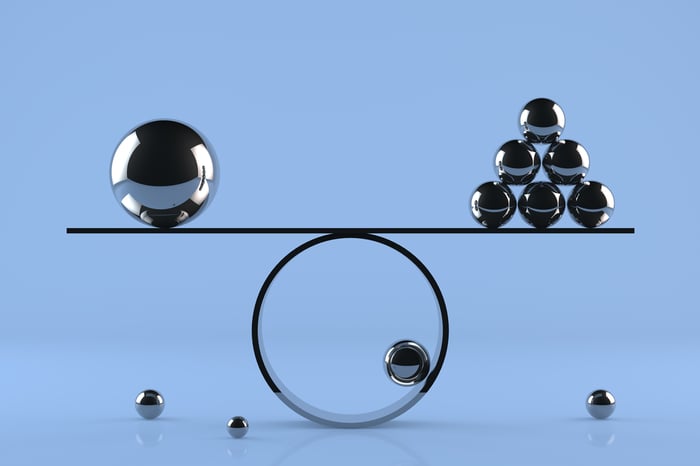 Metallic balls of various sizes are balanced on a large ring.