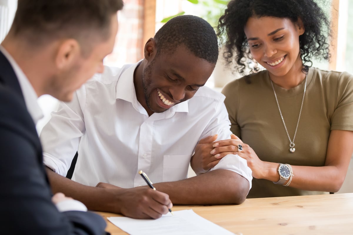 happy couple buying home signing check financial future-1200x800-5b2df79