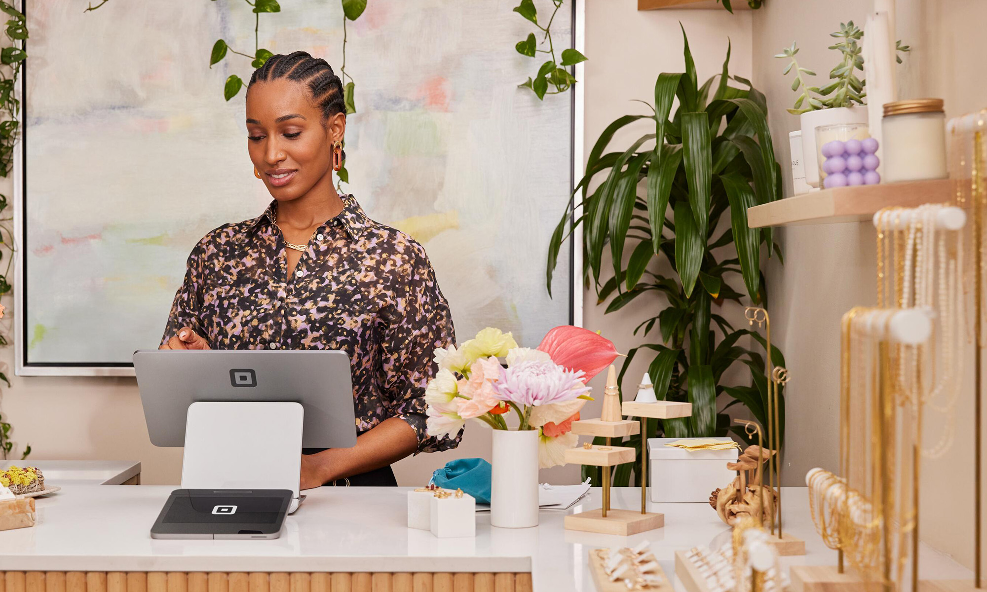 person using square block device behind counter while square block device logo is in view_block