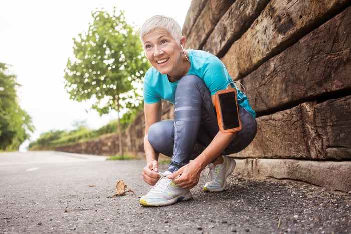 A person lacing up their sneakers for a run.