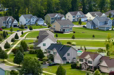 A photo of several houses in a new residential suburb, surrounded by lush greenery