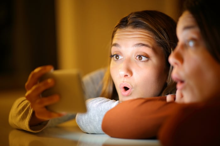 People are looking at a smartphone.