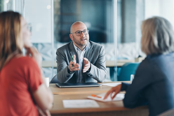 Three people in a meeting.