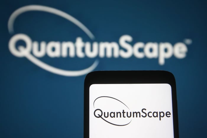 QuantumScape logo on a wall and on a smart phone in front of it.
