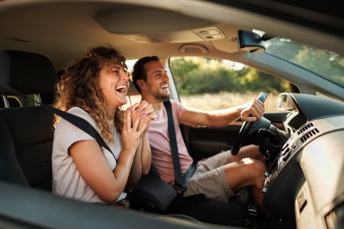 A couple enjoying a drive in a car.