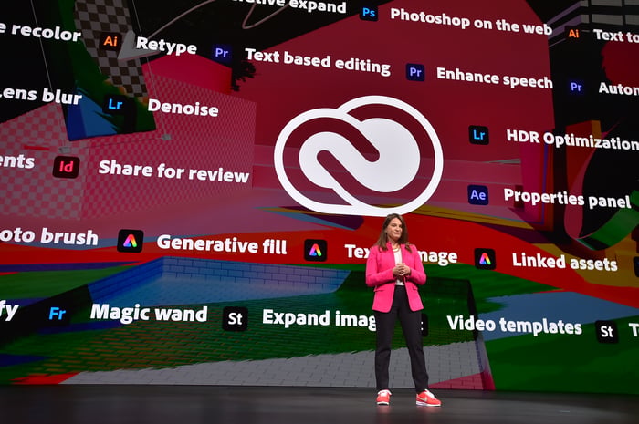 Businessperson giving Adobe presentation on stage.