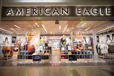 american eagle storefront in mall with illuminated american eagle logo and mannequins-AEO