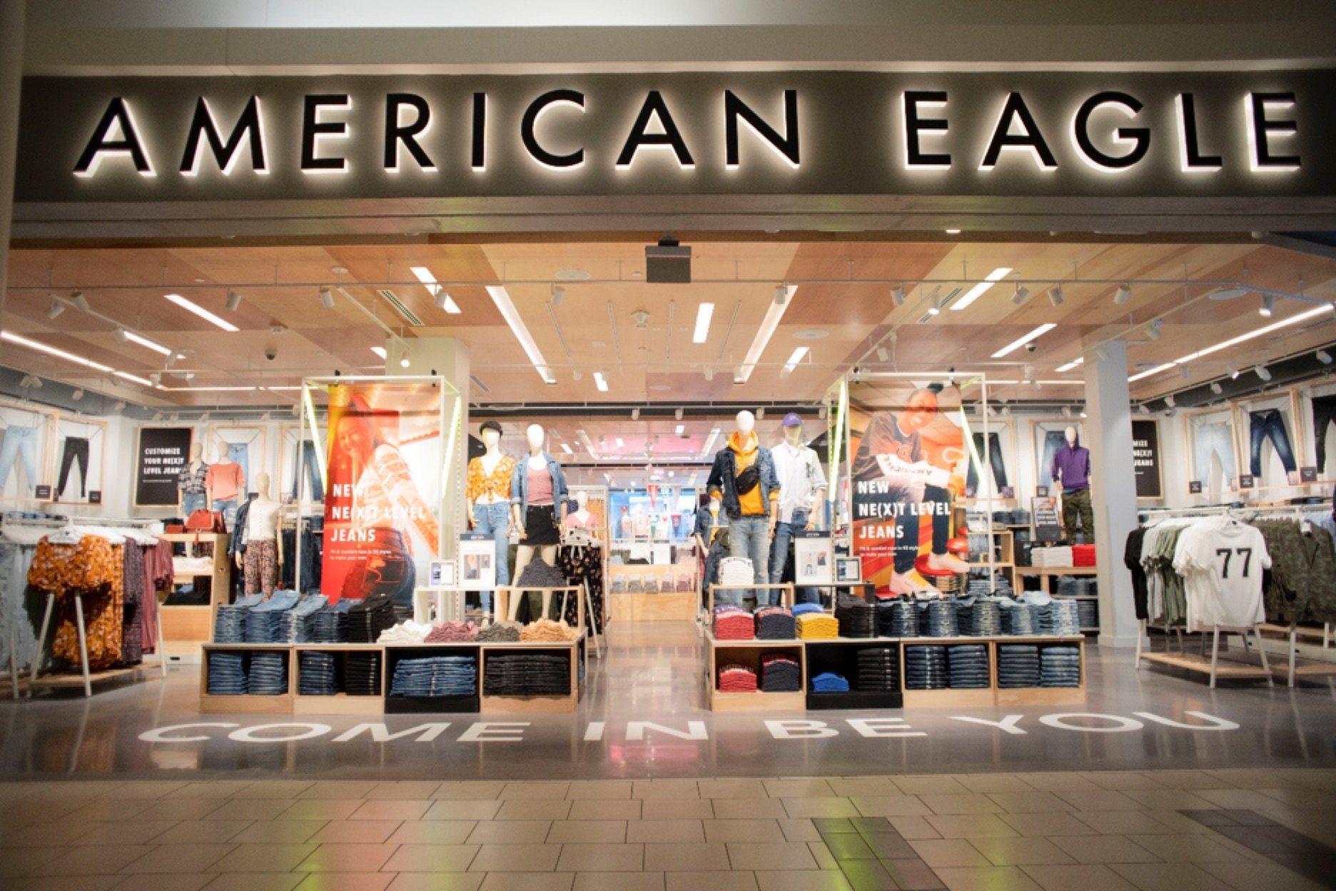 american eagle storefront in mall with illuminated american eagle logo and mannequins-AEO
