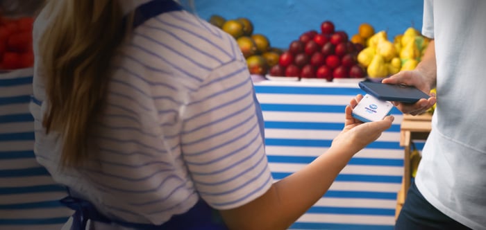 A customer tapping to make a payment with Mercado Pago. 