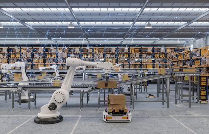 Robotic machines are moving packages inside an automated warehouse. 