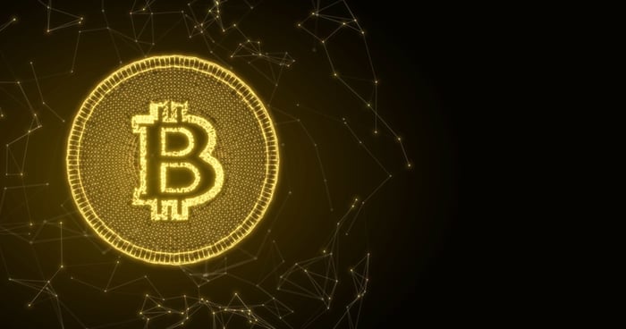 Bitcoin logo on gold token.
