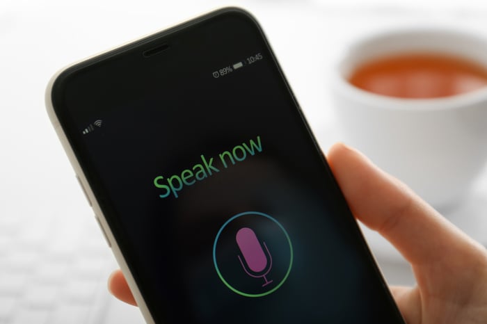 The screen of a smart phone with a microphone icon and text that reads "Speak Now"