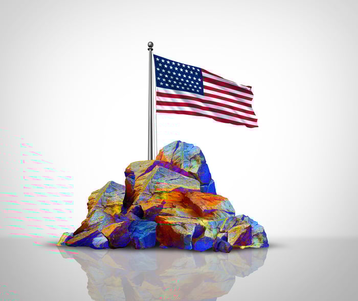 A conceptual image shows a rare-earth element with an American flag sticking out.