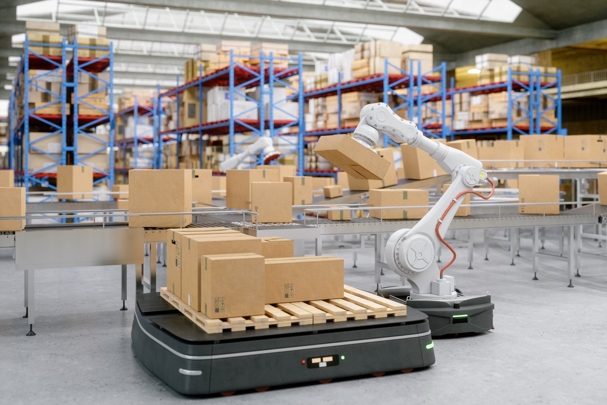 Robot loading boxes on a wooden pallet carried by another robot in a warehouse.