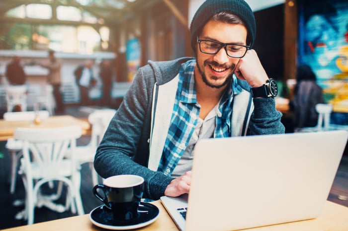 A person at a laptop in a cafe.