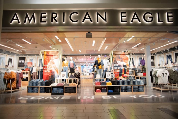 An American Eagle storefront is illuminated inside a shopping mall.