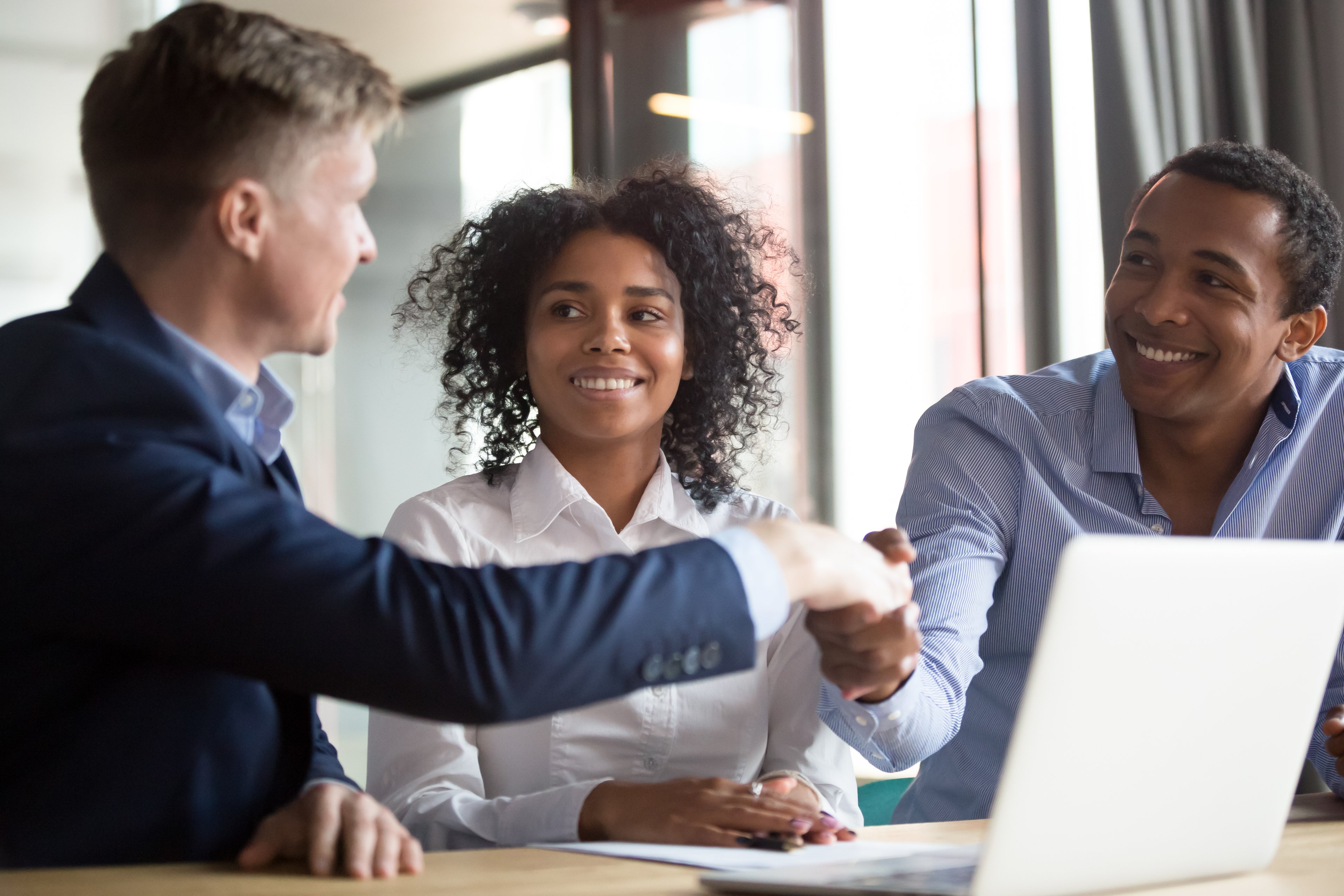 investors smile while gesturing at computer