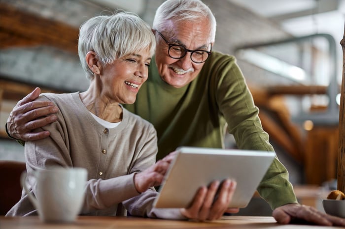 A couple looking at a tablet.