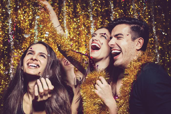 Three people celebrate the new year at a party.