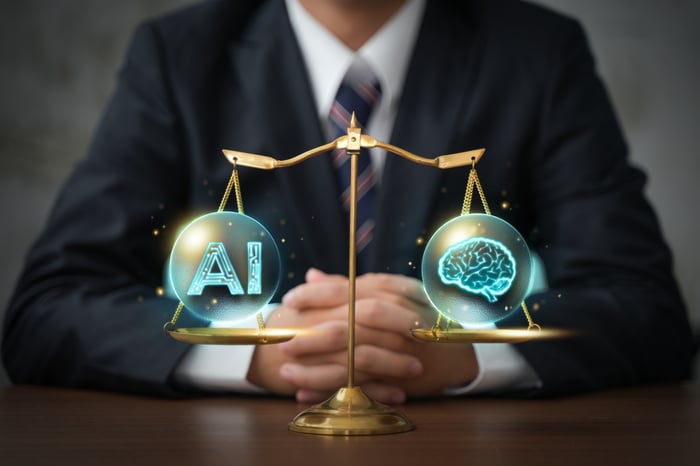 A business person sits facing a balanced scale with AI on one pan and human intelligence on the other. 