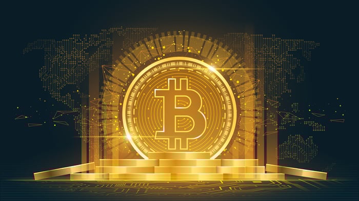 Bitcoin logo with gold backdrop.