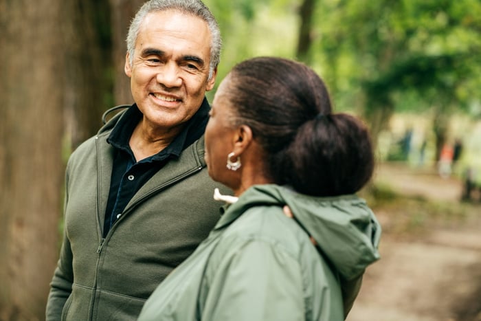Two people taking a hike through the woods.