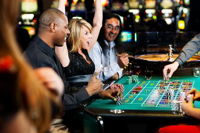 Woman cheering at a casino roulette table.