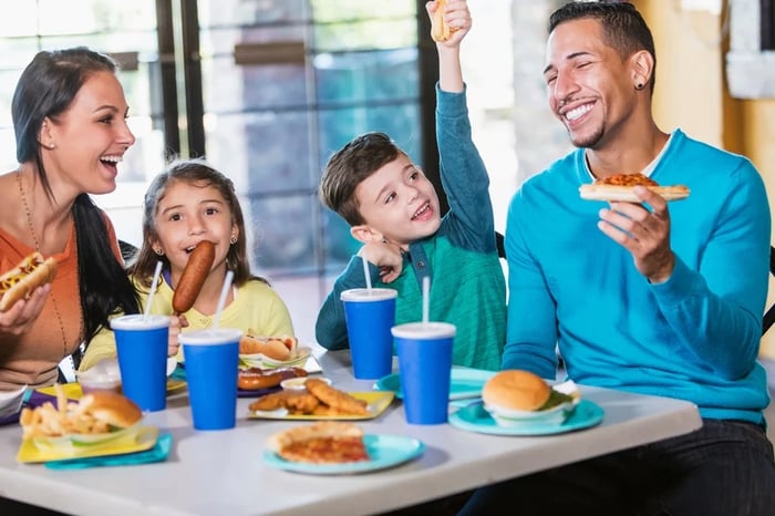 A family enjoying a meal out in a fast-food joint.