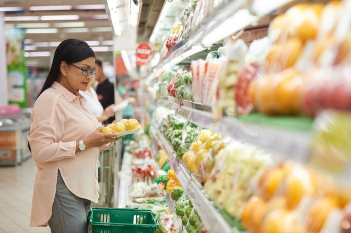 A person examines produce in a store.