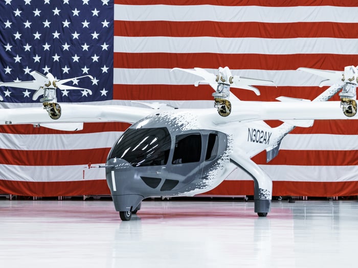 An Archer Aviation Midnight aircraft in front of an American flag. 