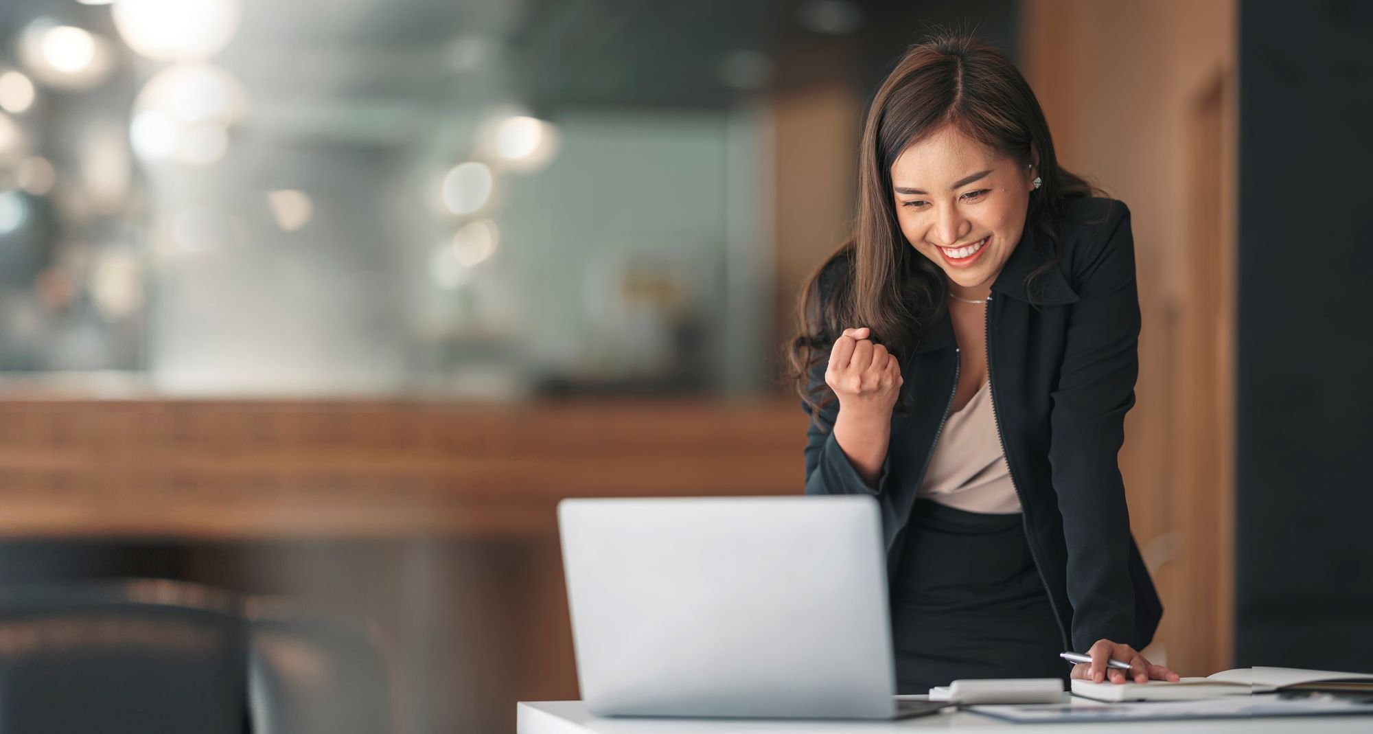 An excited businessperson looking at their computer.