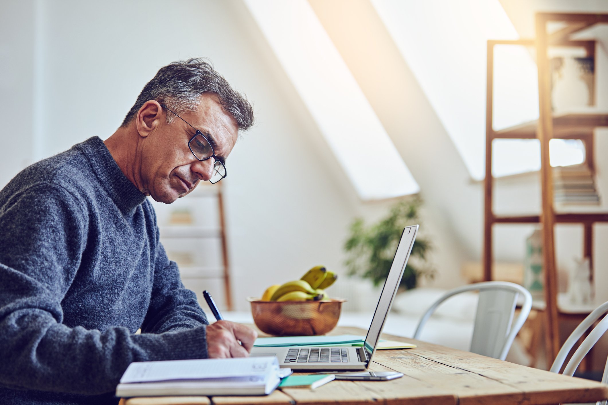 Older man at laptop taking notes_GettyImages-874867586