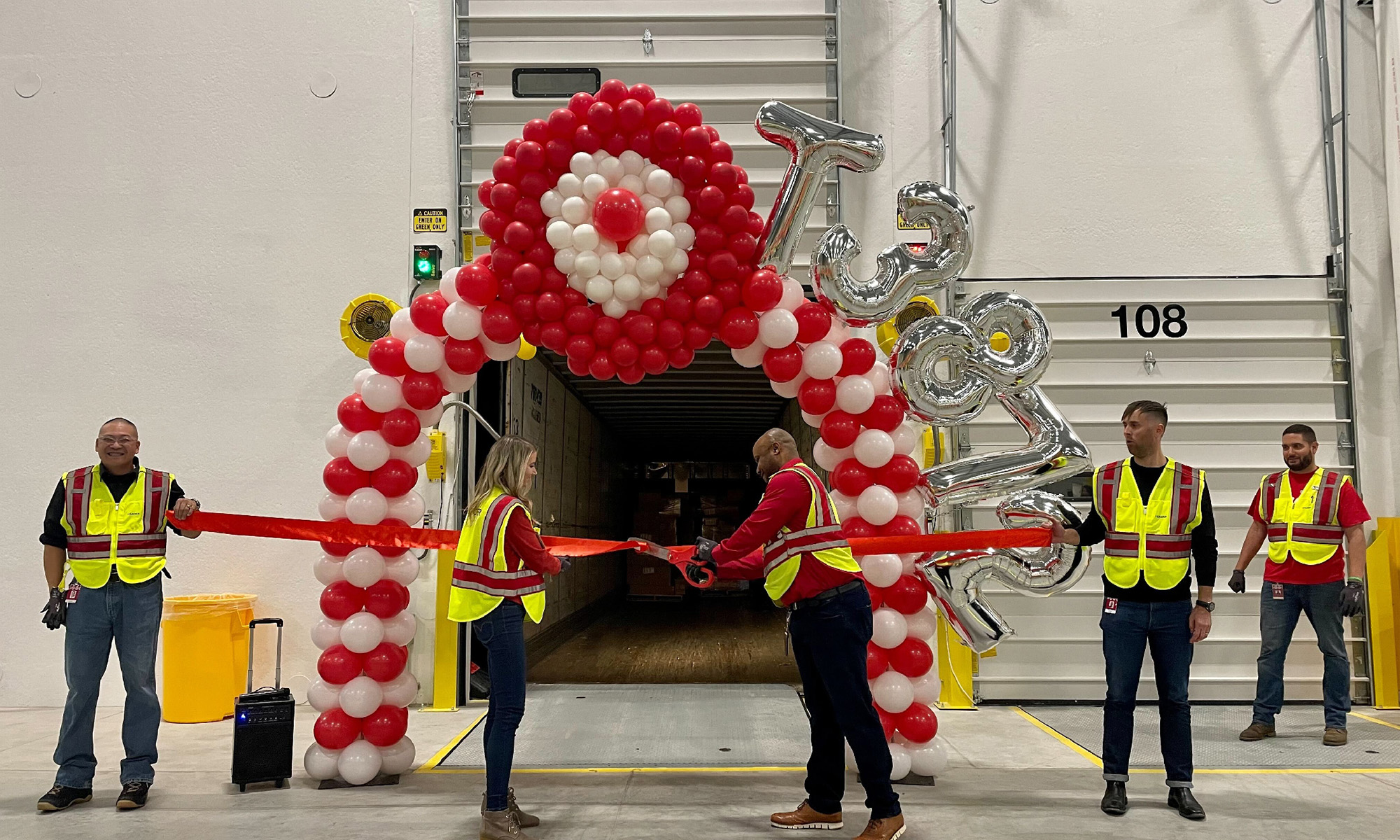 sorting center with balloons in shape of__target logo while employees cut ribbon_target_