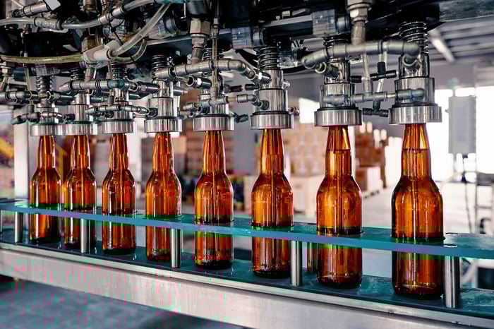 Beer being bottled on an assembly line.