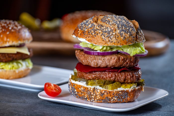 A plant-based meat burger sitting on a plate.