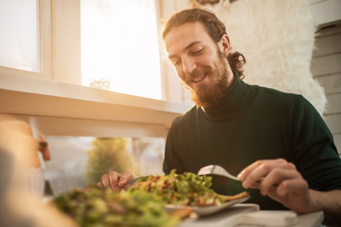 Person eating a salad at a restaurant.