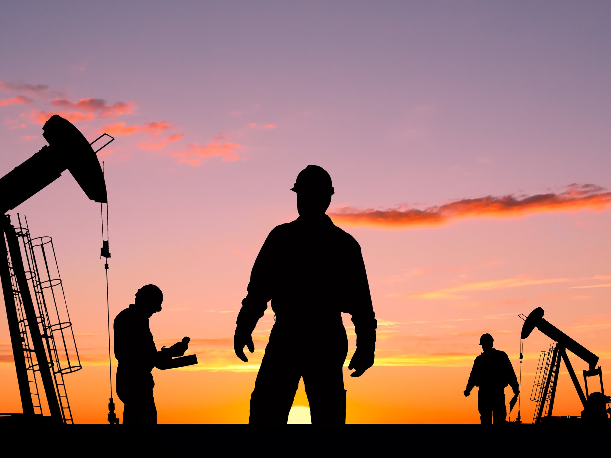 22_03_07 Three people in silhouette with oil rigs in the background _GettyImages-154890896