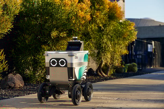 A Serve Robotics delivery robot rolling down a sidewalk.