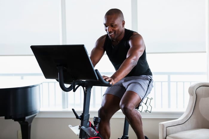 Someone is on an exercise bike, smiling.