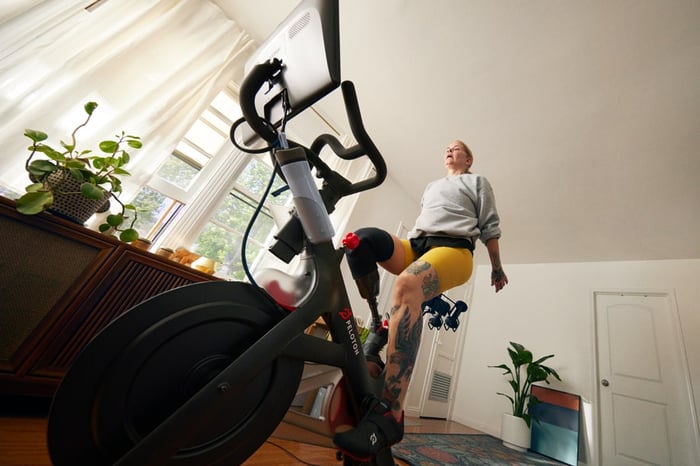 A woman on a Peloton in her living room.