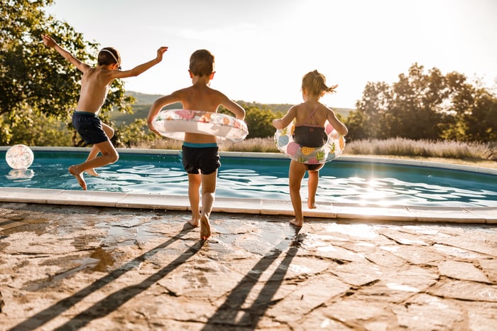 Children jumping into a pool.