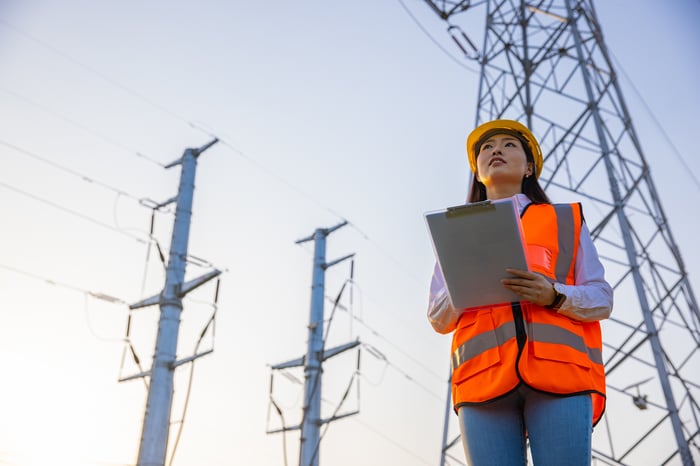 An electrical engineer working near high-voltage utility towers.