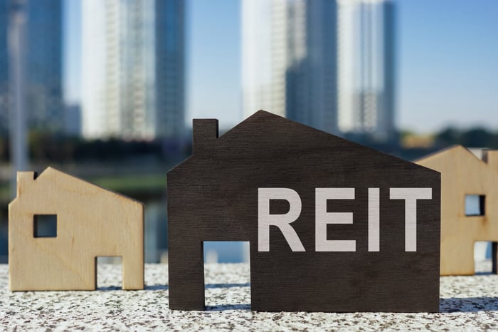 The word REIT on a cardboard cutout house.